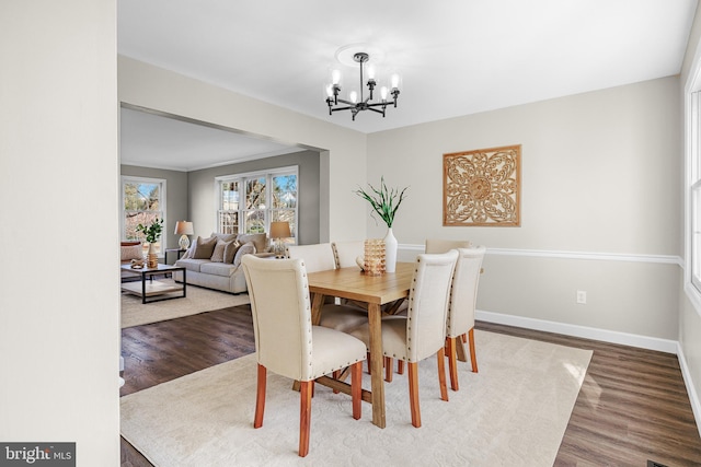 dining space featuring dark hardwood / wood-style flooring and a chandelier