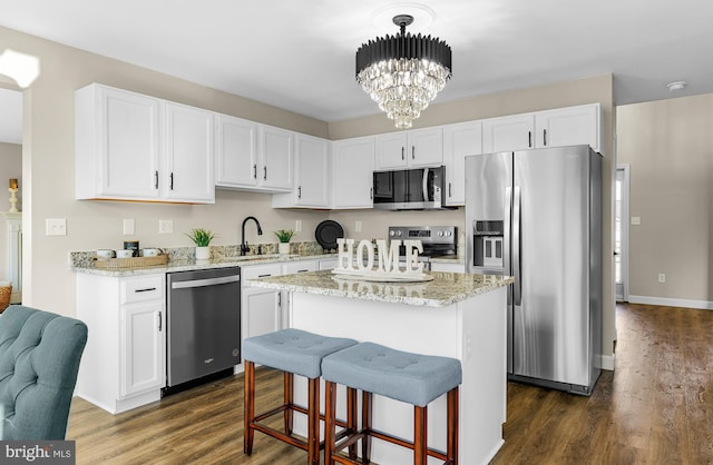 kitchen featuring pendant lighting, a center island, white cabinets, and appliances with stainless steel finishes