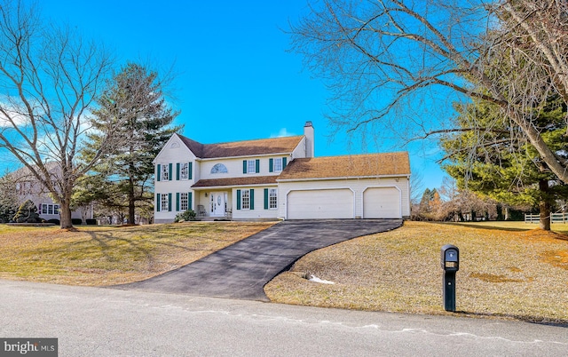 view of front of house with a garage and a front lawn