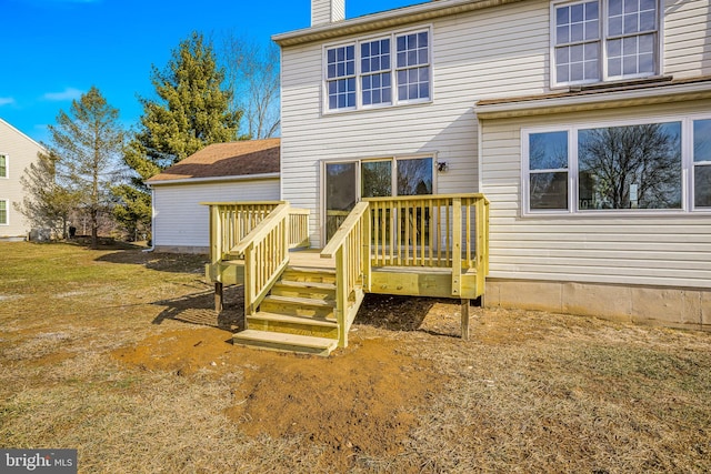 back of house featuring a wooden deck and a yard