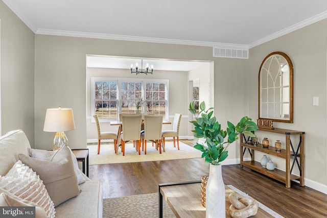 dining area featuring ornamental molding, an inviting chandelier, and dark hardwood / wood-style flooring