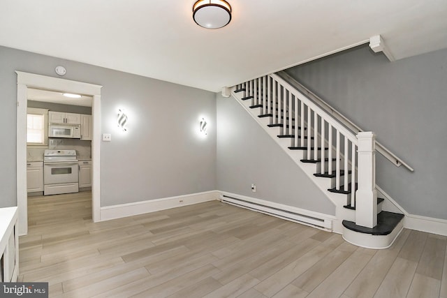 stairway featuring wood-type flooring and baseboard heating