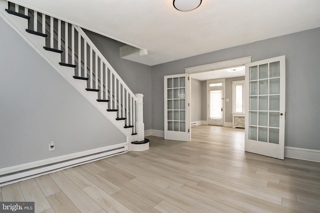 foyer featuring a baseboard heating unit, light hardwood / wood-style flooring, and french doors