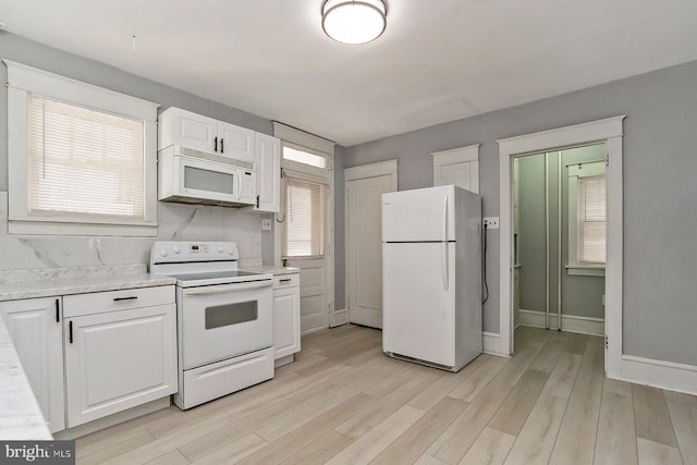 kitchen featuring white cabinets, white appliances, and light hardwood / wood-style flooring