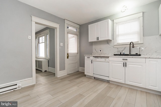 kitchen with sink, dishwasher, backsplash, light stone countertops, and white cabinets