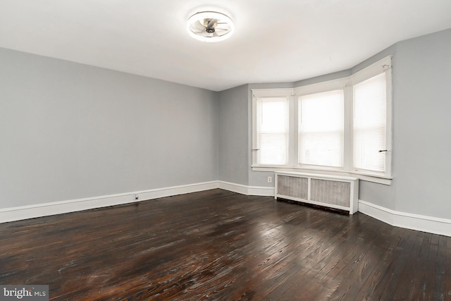 spare room with radiator heating unit and hardwood / wood-style floors