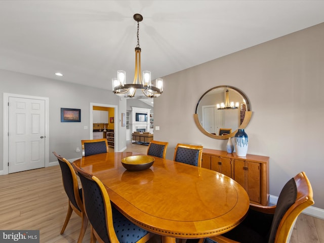 dining space with an inviting chandelier and light hardwood / wood-style flooring