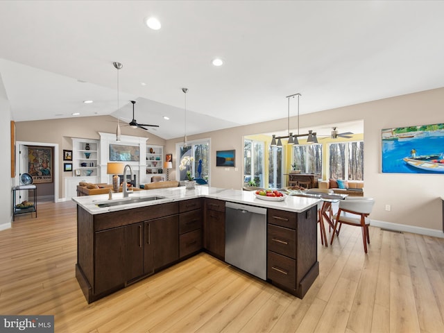 kitchen featuring pendant lighting, sink, dark brown cabinets, a center island with sink, and stainless steel dishwasher