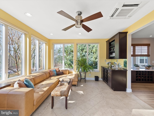 sunroom / solarium featuring bar and ceiling fan