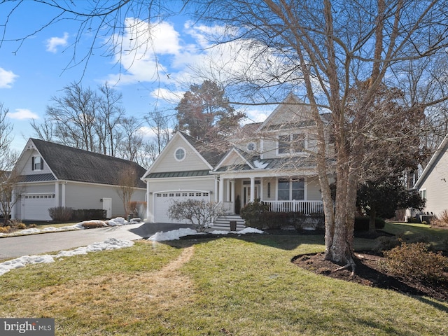 view of front facade featuring a garage, a front yard, and covered porch