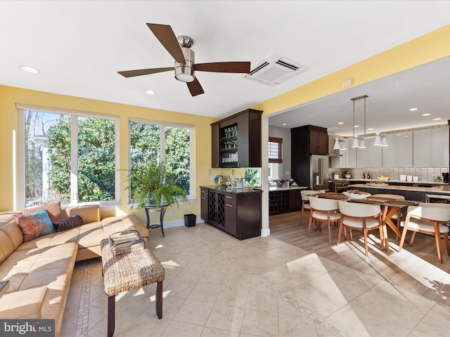 tiled living room featuring ceiling fan and indoor bar