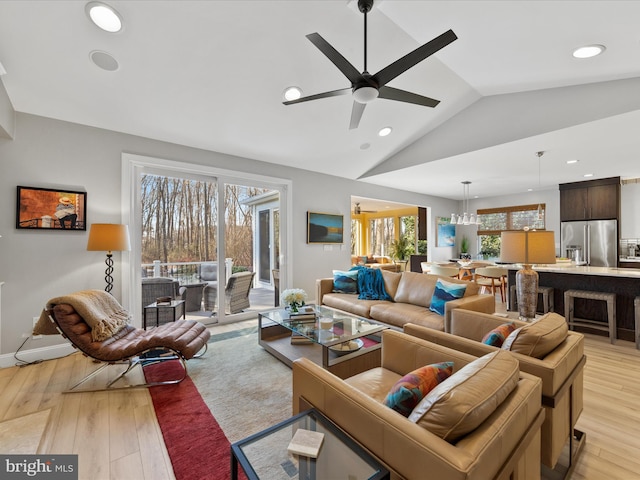 living room with ceiling fan, lofted ceiling, and light hardwood / wood-style floors