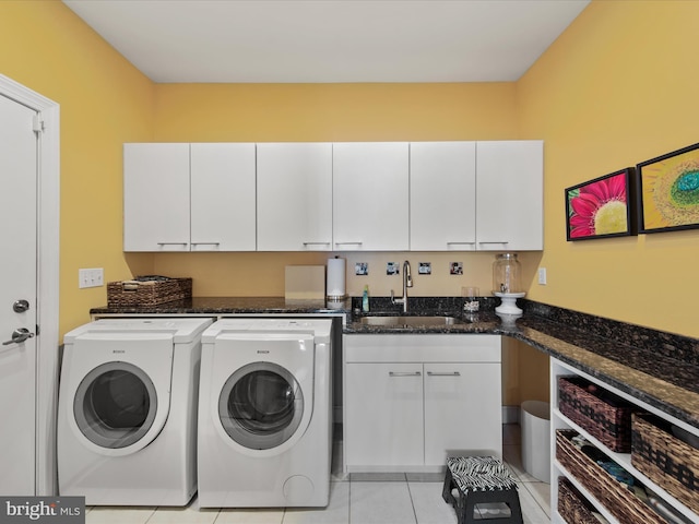 clothes washing area featuring light tile patterned flooring, washing machine and clothes dryer, sink, cabinets, and beverage cooler