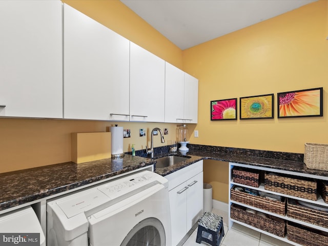 clothes washing area with cabinets, separate washer and dryer, sink, and light tile patterned floors