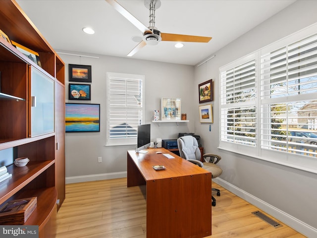 home office with light hardwood / wood-style floors and ceiling fan