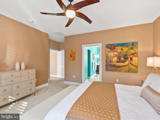 bedroom with ceiling fan, connected bathroom, and light carpet