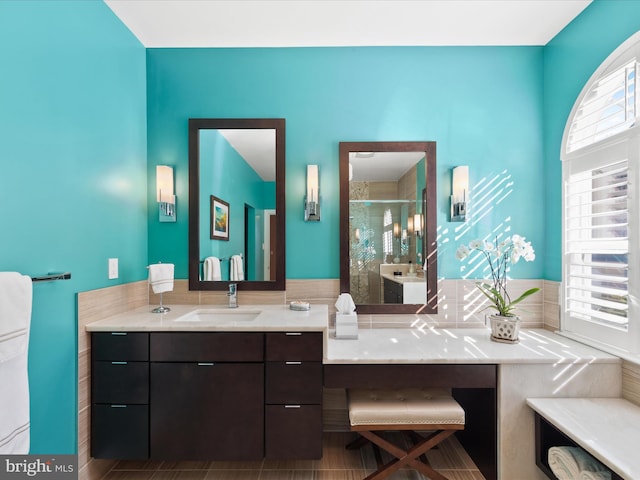 bathroom featuring vanity and a shower with door