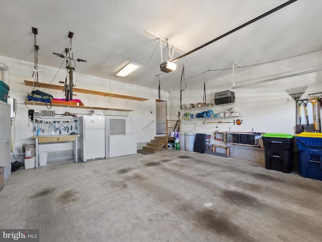 garage with white refrigerator, a garage door opener, and a workshop area