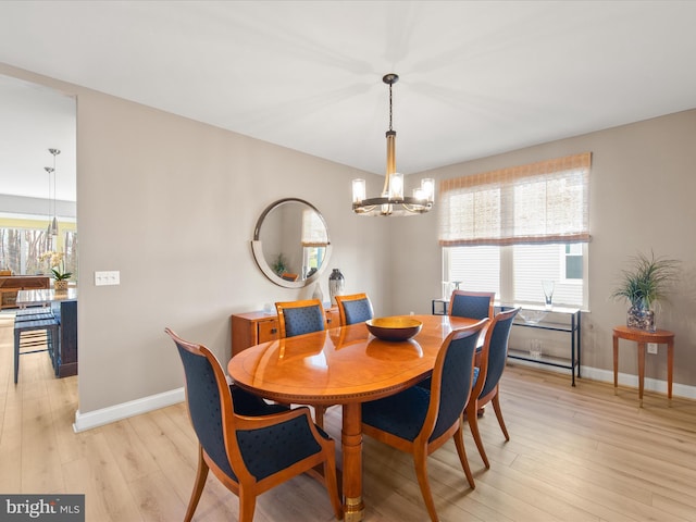 dining space featuring an inviting chandelier and light wood-type flooring