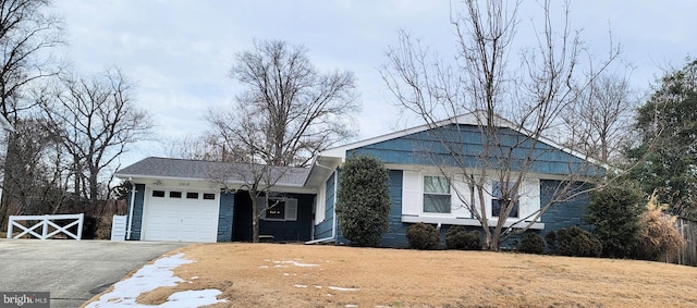 view of front of property with a garage and a front lawn