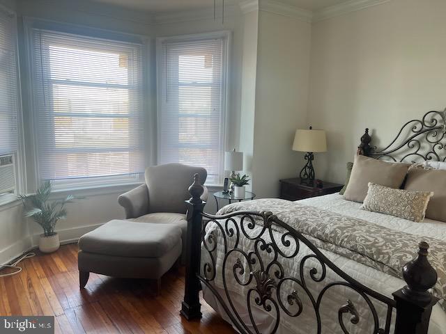 bedroom featuring ornamental molding and wood-type flooring