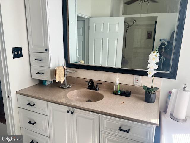 bathroom with vanity and a tile shower