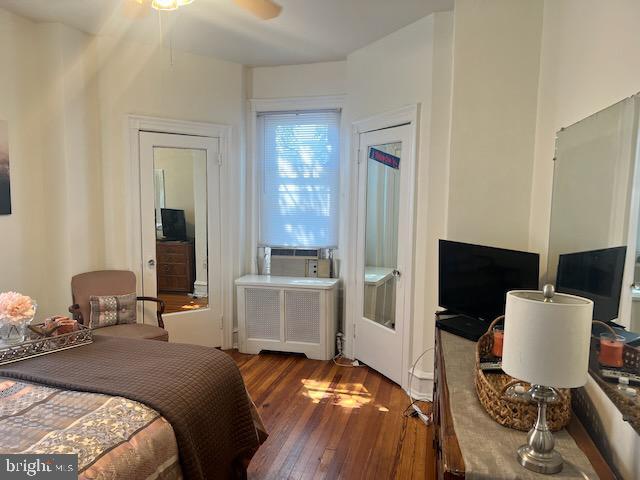 bedroom featuring wood-type flooring and radiator heating unit