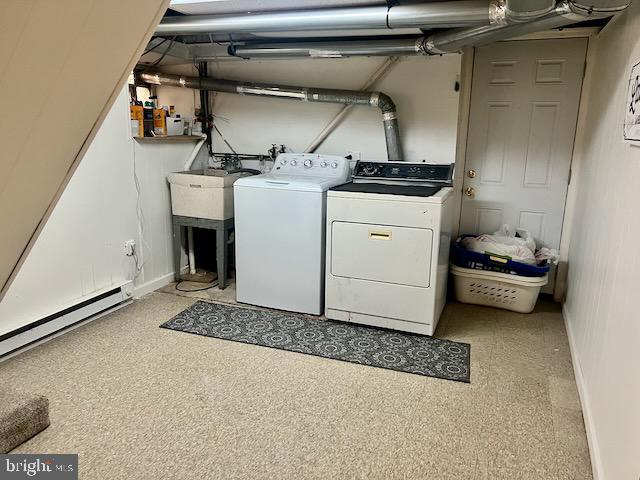 laundry room featuring a baseboard heating unit, sink, and independent washer and dryer