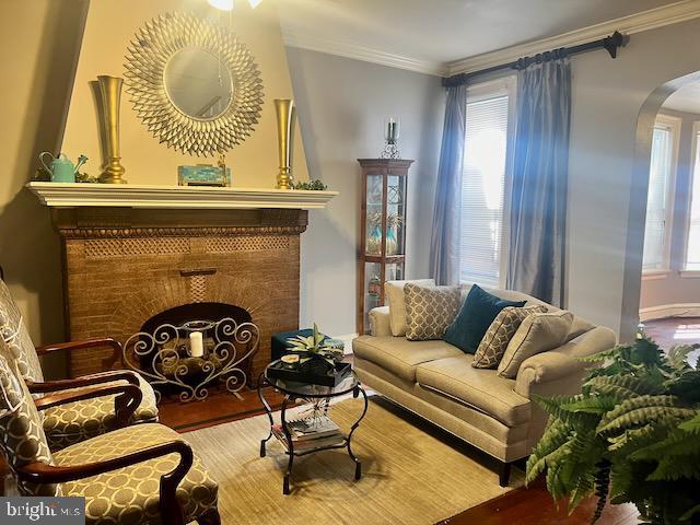 sitting room with ornamental molding and hardwood / wood-style floors