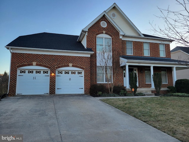 view of front facade with brick siding, a front lawn, a porch, concrete driveway, and an attached garage