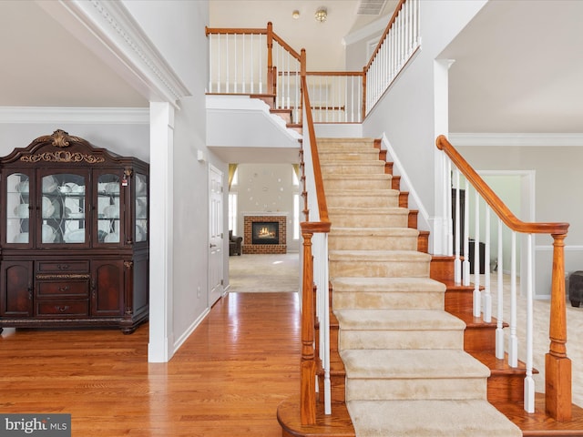 entryway with stairs, crown molding, baseboards, and wood finished floors