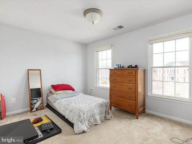 bedroom with visible vents, baseboards, and light colored carpet