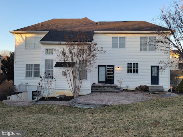 rear view of property featuring entry steps, a lawn, and a patio