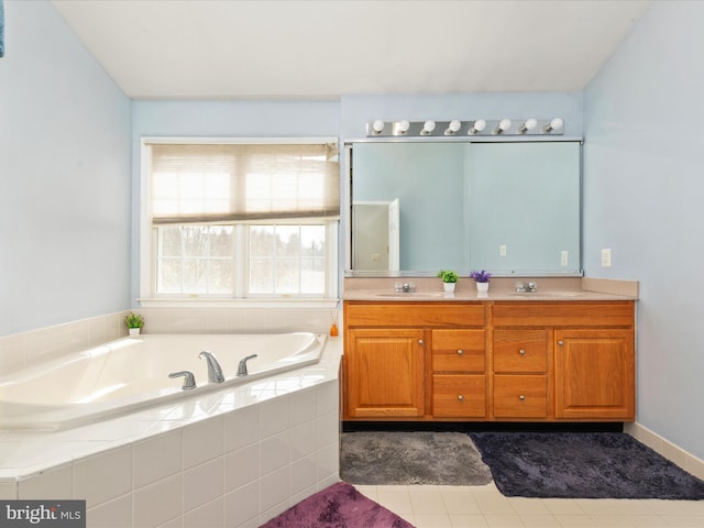 bathroom featuring double vanity, a bath, and a sink