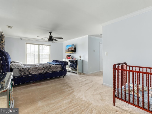 carpeted bedroom with ceiling fan, visible vents, baseboards, and ornamental molding