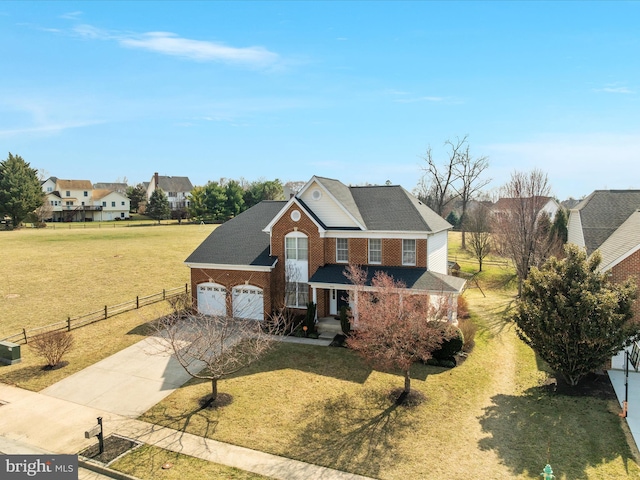traditional home with fence, an attached garage, concrete driveway, a front lawn, and brick siding