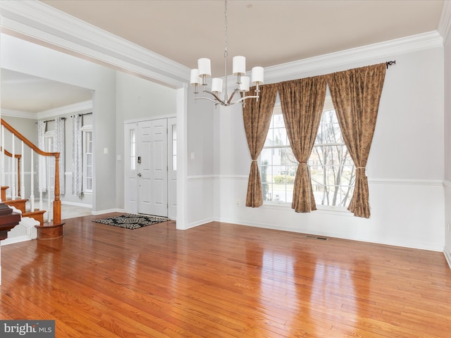 entryway with stairs, a notable chandelier, visible vents, and ornamental molding