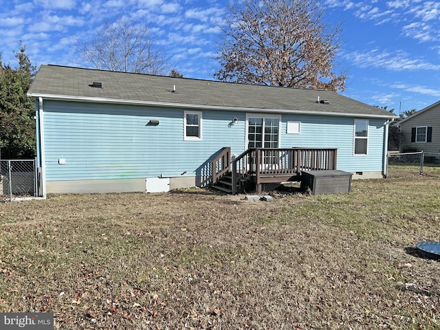 back of property with a wooden deck and a yard