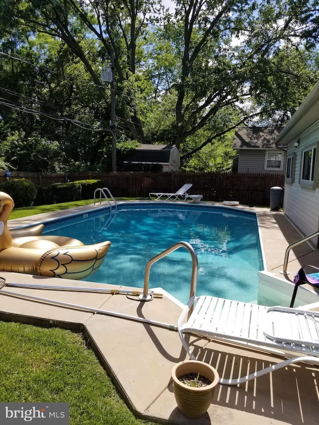 view of swimming pool featuring a diving board