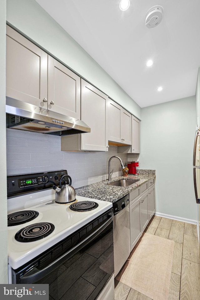 kitchen featuring dishwasher, sink, decorative backsplash, light wood-type flooring, and electric stove