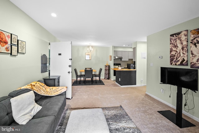 carpeted living room featuring a chandelier