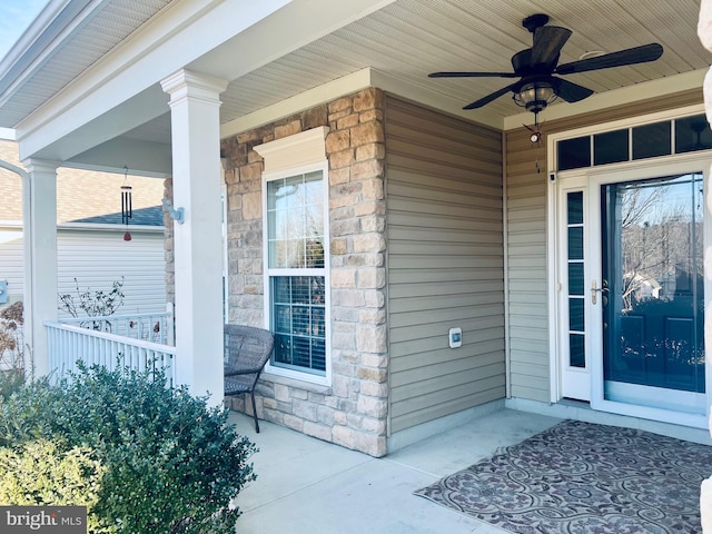 view of exterior entry featuring ceiling fan and covered porch