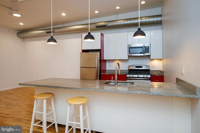 1215 N Hancock St, Philadelphia, PA 19122 - kitchen featuring sink, hanging light fixtures, appliances with stainless steel finishes, kitchen peninsula, and white cabinets
