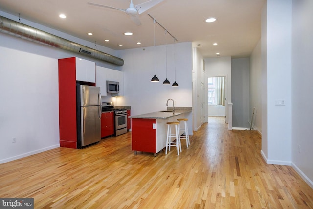 1215 N Hancock St, Philadelphia, PA 19122 - kitchen with appliances with stainless steel finishes, sink, white cabinets, a kitchen bar, and kitchen peninsula