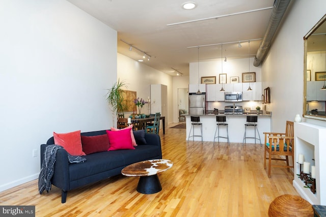 1215 N Hancock St, Philadelphia, PA 19122 - living room featuring track lighting, a towering ceiling, and light wood-type flooring