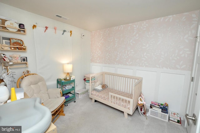 carpeted bedroom featuring a crib