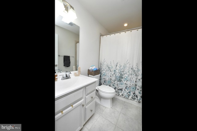 bathroom featuring vanity, tile patterned floors, and toilet