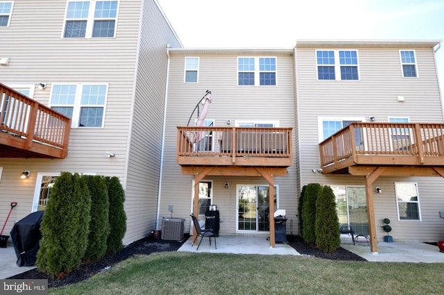 back of property with central AC unit, a patio, and a lawn