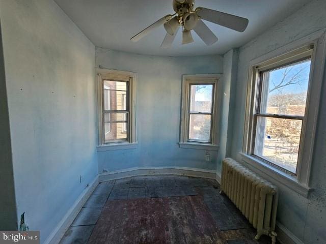 empty room with ceiling fan and radiator heating unit