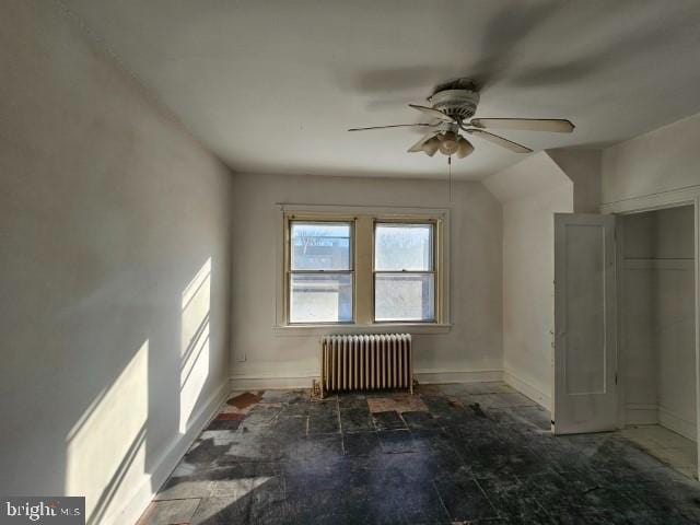 bonus room featuring ceiling fan and radiator